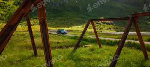 Preview: Lone car travelling on a rode at a rural landcape in Lofoten, Norway