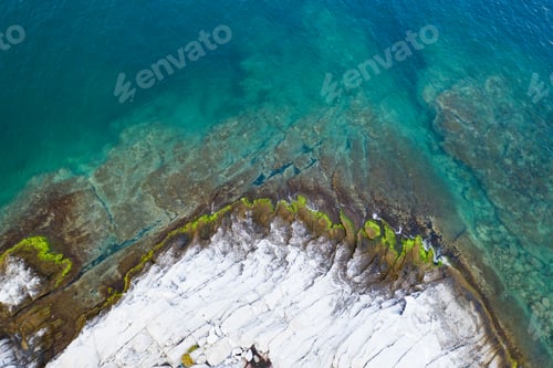Preview: Aerial drone view of a remote rocky island in open sea.