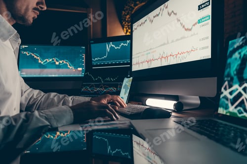 Preview: Close-up of financial broker working on computer while trading on stock market in night office
