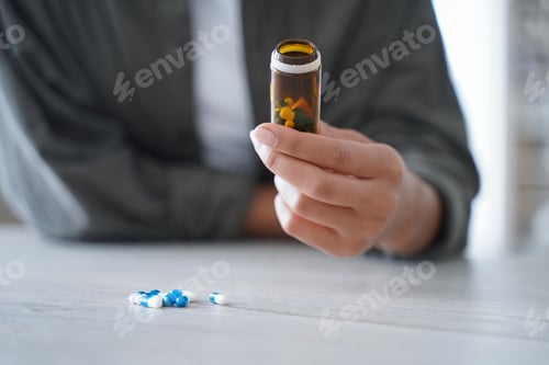 Preview: Closeup woman hold pills bottle of nutritional dietary supplements or medicine. Healthcare, wellness