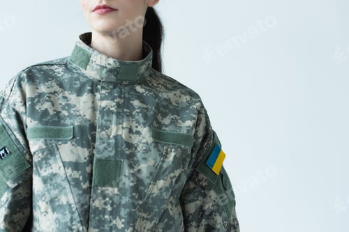 Preview: Cropped view of woman in military uniform with chevron of ukrainian flag isolated on grey