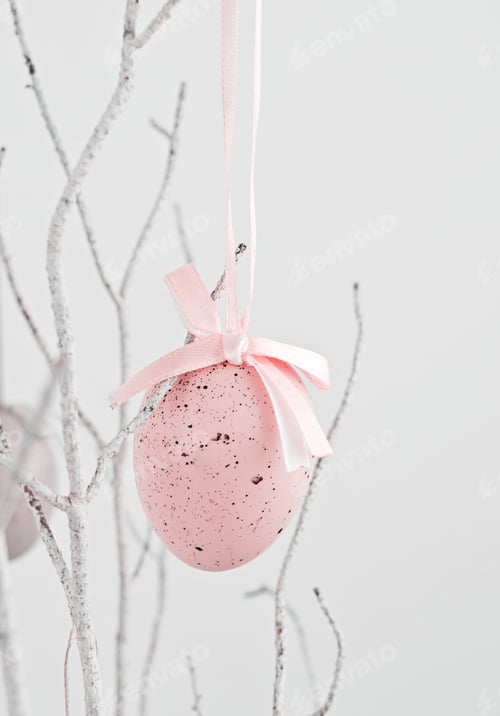 Preview: Pink decorative Easter egg hanging on dry branch on white