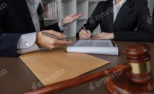 Preview: Businessman and lawyer discussing business contract document for legal advice in lawyer's office.