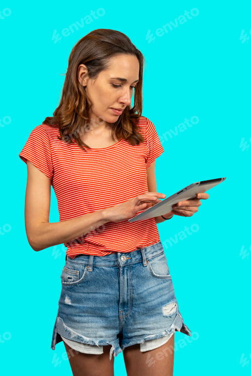 Preview: Young woman using digital tablet on turquoise background