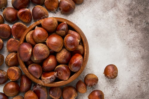 Preview: Pile of fresh sweet chestnuts in a bamboo bowl. Top view, copy space
