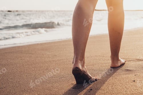 Preview: Beach travel - woman walking on sand beach leaving footprints in the sand.