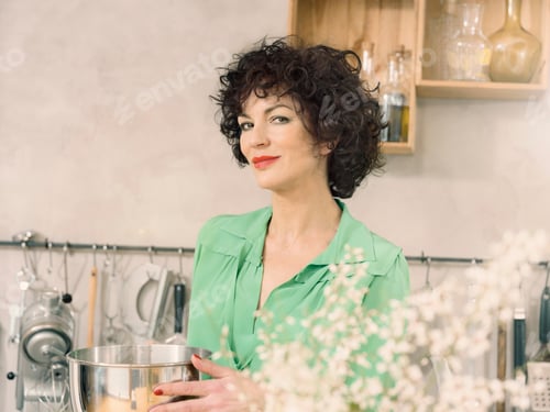 Preview: Portrait of woman in kitchen at camera smiling
