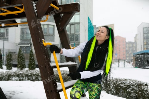 Preview: Woman Climbing up Wooden Ladder in Snow