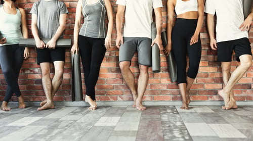 Preview: Young people waiting for yoga class in studio.