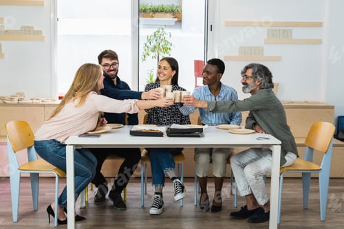 Preview: Diverse colleagues having lunch together in kitchen of office