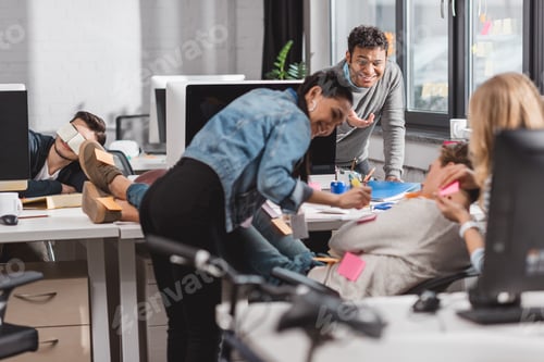 Preview: people having fun in office, women glue stickers on man