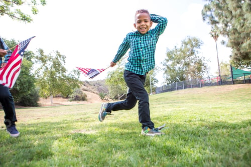 Preview: Children playing with American flag in park