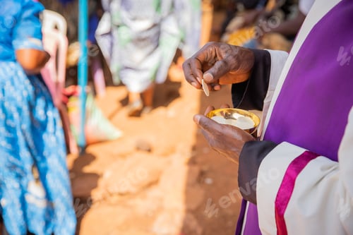 Preview: Close-up of the hands of an African priest who is about to give the sacramental bread to believers.