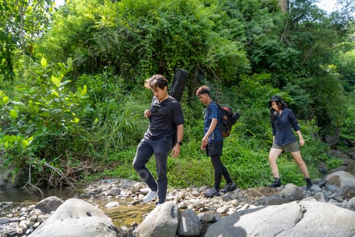Preview: group of young asian trekking and hiking on rocky river stream