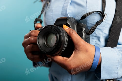 Preview: Close up of professional photographer with photo camera getting ready for shooting session