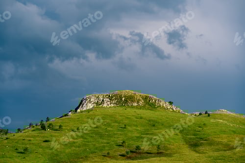 Preview: Green mountain against a dark cloudy sky in Durmitor National Park