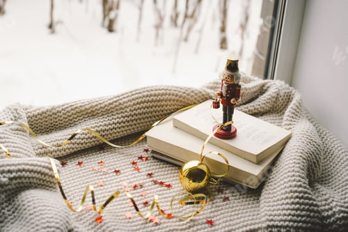 Preview: Festive holiday greeting with a nutcracker and decorations on a cozy knitted blanket