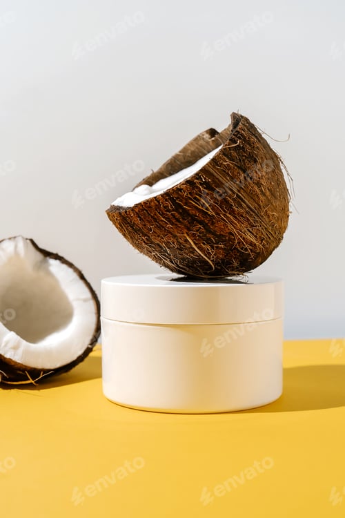 Preview: Two halves of coconut and a jar of cosmetics on a yellow and gray background.