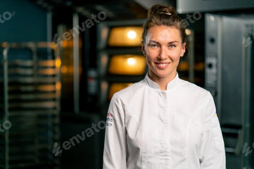 Preview: chef baker in a professional uniform in a bakery against background of an oven and fresh baked goods