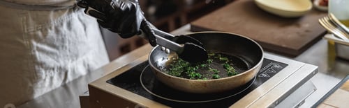 Preview: Close up of kitchen worker is frying greens for cooking main dish in restaurant