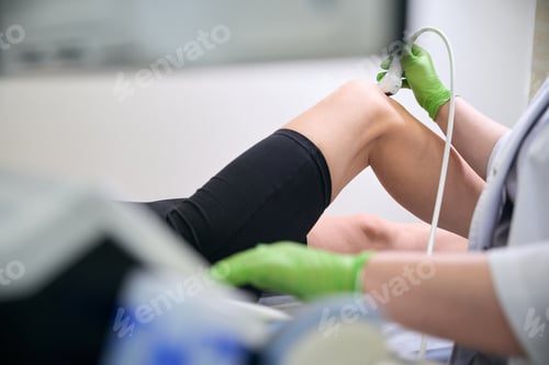 Preview: Close-up of doctor hand holding ultrasound probe during scan