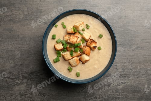 Preview: Bowl of fresh homemade mushroom soup on gray background, top view