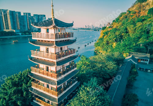Preview: Setting sun shines on a tower by the river in Liuzhou, Guangxi, China, Asia