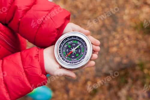 Child Hands Holding Compass in Outdoor Setting