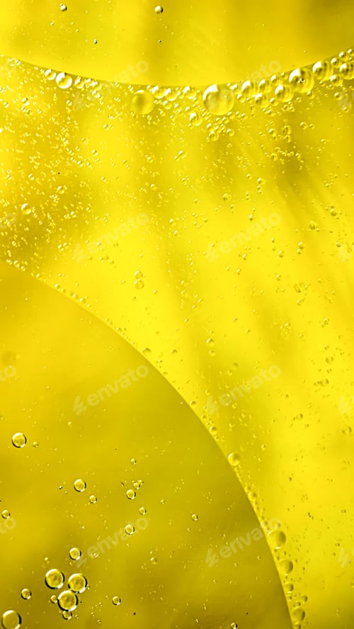 Preview: oil drops on water on yellow background
