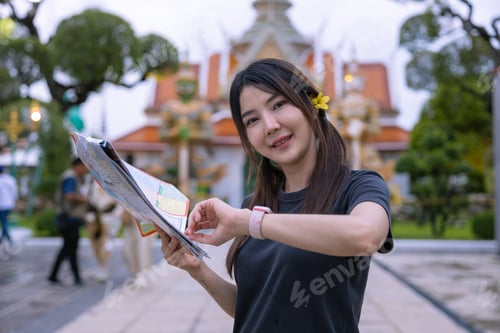 Preview: Tourists Examining Map Near Illuminated Temple