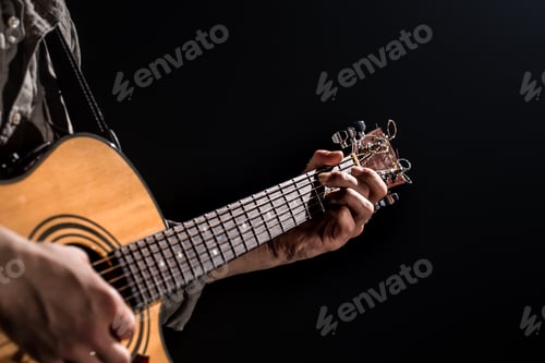 Preview: Guitarist, music. A young man plays an acoustic guitar on a black isolated background