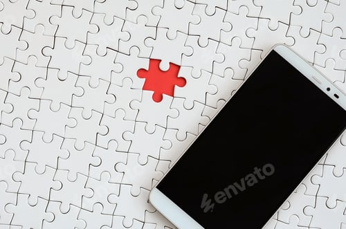 Preview: A modern big smartphone with a touch screen lies on a white puzzle puzzle in an assembled state