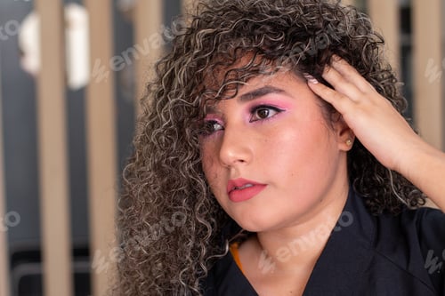 Preview: Portrait of beautiful curly haired woman posing and showing off her beautiful new hair color.