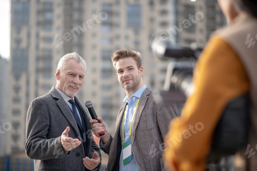 Preview: Reporters from television interviewing a famous businessman