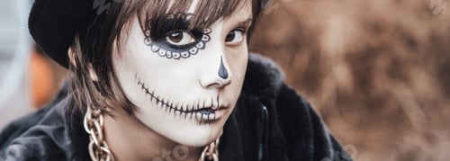 Preview: Beautiful scary little girl celebrating halloween. Terrifying black, white half-face makeup and witc