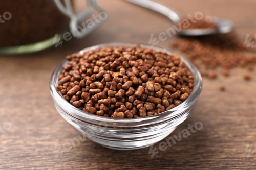 Preview: Buckwheat tea granules in glass bowl on wooden table, closeup