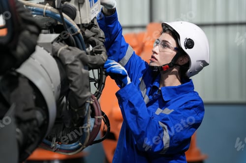 Preview: Robotics engineer working on maintenance of robotic arm in factory warehouse. Business technology.