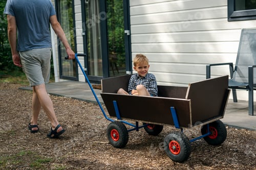 Preview: A man pulling a wooden wagon with his son.