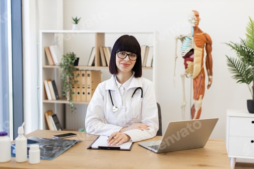 Preview: Confident female doctor at office desk ready to assist patients