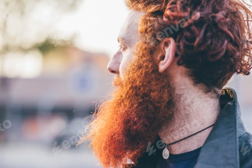 Preview: Man with a vibrant red beard in profile view