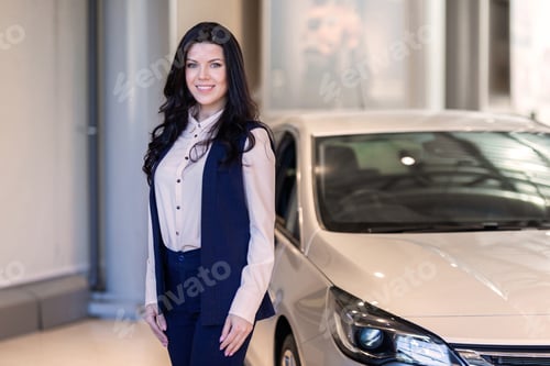 Preview: Beautiful saleswoman possing near new car in dealership center