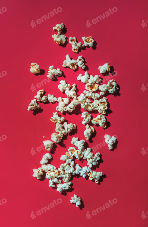 Preview: Scattered salty popcorn on viva magenta color background, top view