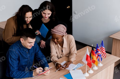 Preview: Mixed-nationality class working with teacher and laptop in collaborative study