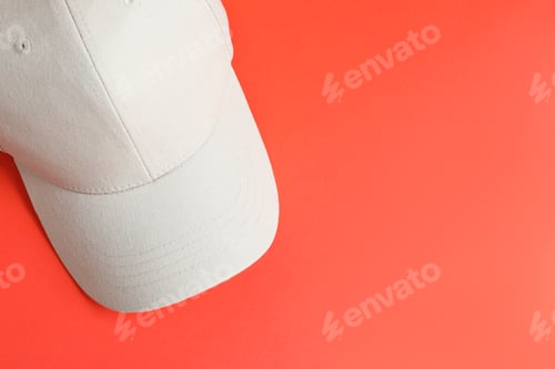 Preview: Beige baseball hat on coral background, top view. Space for text
