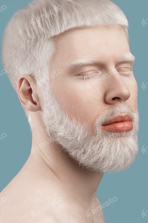 Preview: Albinism concept. Headshot of young albino man with closed eyes, pale skin and white hair posing on