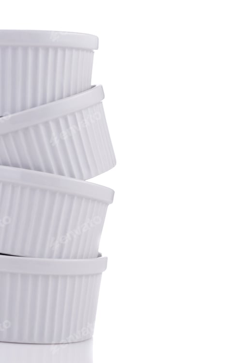 Preview: White ramekin dishes very unstable stack close-up isolated on white background