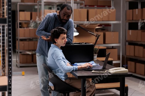 Preview: Warehouse workers analyzing checklist on laptop computer searching for metallic box order