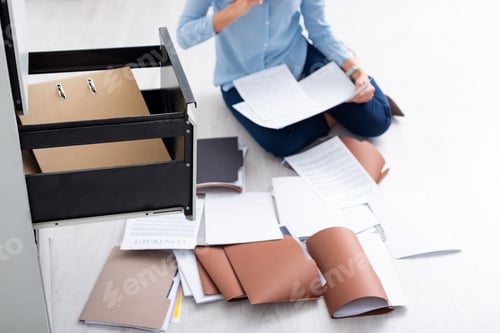 Preview: Cropped view of businesswoman with contract and documents near open cabinet driver on floor
