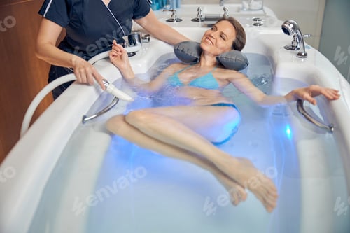 Preview: Smiling woman patient undergoing a hydrotherapy procedure