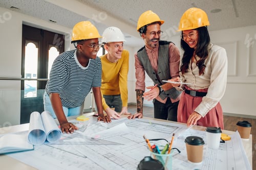 Preview: Multiracial team of architects having a meeting while using blueprints